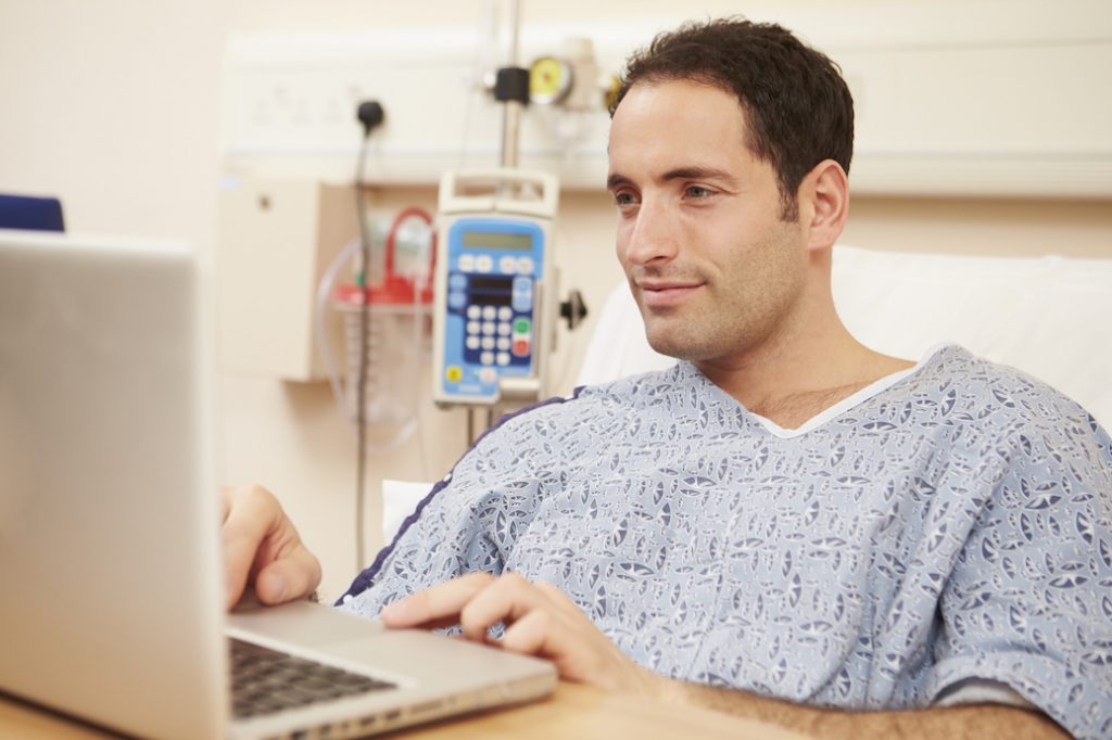 AktiverPatient-1024x682 Patient sitzt im Krankenhaus an seinem Laptop