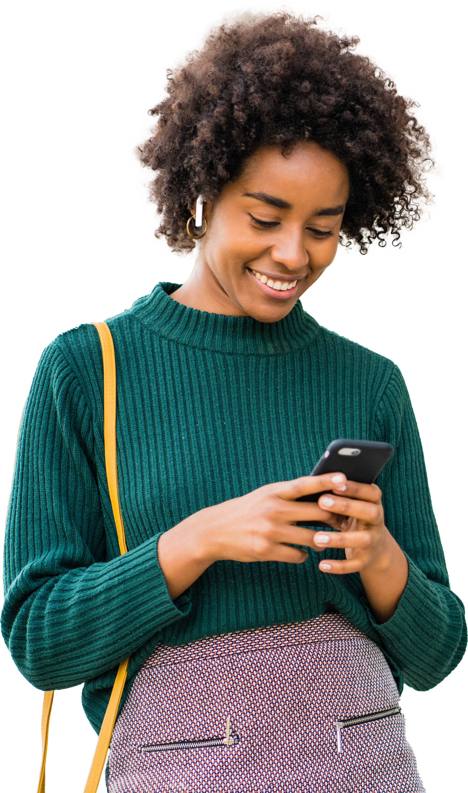 A woman wearing green with a yellow purse strap holding a phone and smiling at it